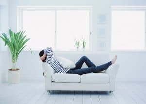 Photo of Woman relaxing on couch near house plant - Want to be happier, healthier, and more productive on Elemental Green