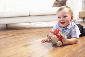 photo of toddler boy playing on the floor