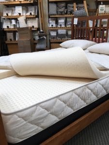 Photo of an Earthsake mattress being pulled back to reveal the organic layers - eco-friendly, healthy bedroom on elemental green eco-friendly mattresses for every budget