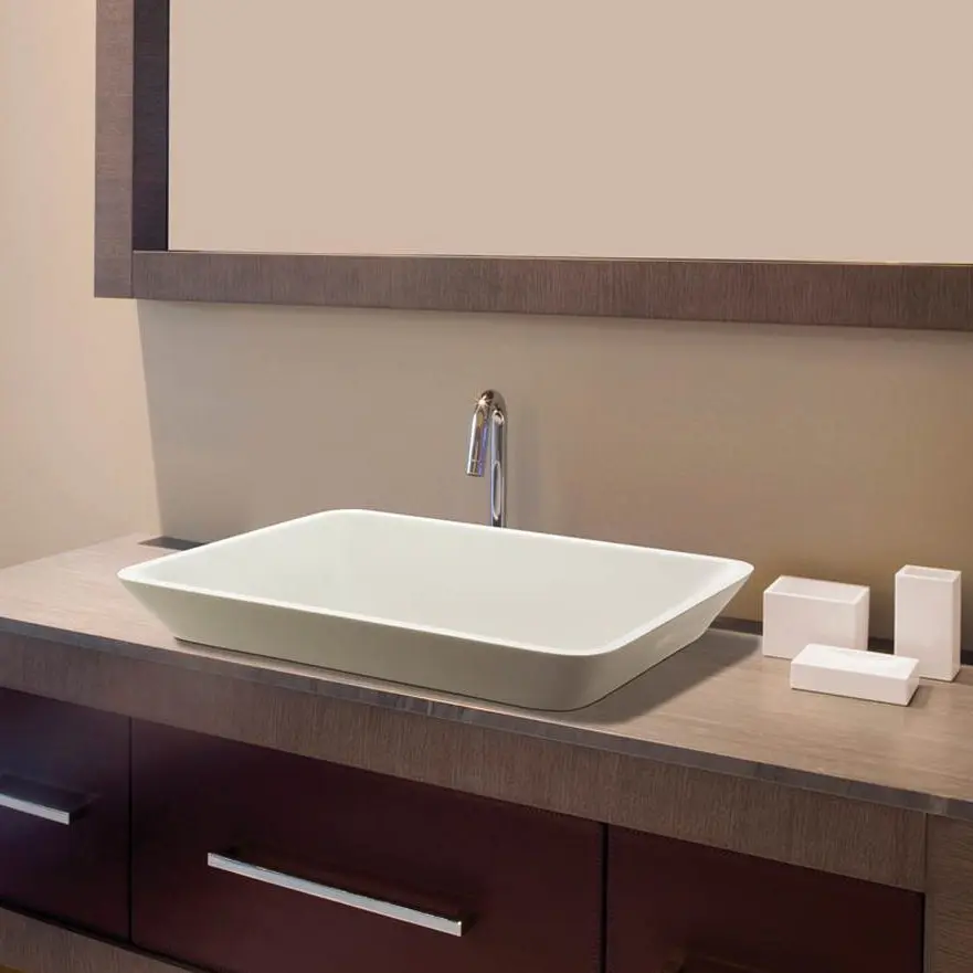 Oblong semirecessed sinks sits on "wood" vanity with drawers; wood frame mirror above.