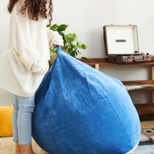 Brentwood Home beanbag lounger is tough enough for this girl to tote; shelving and record player in background - photo