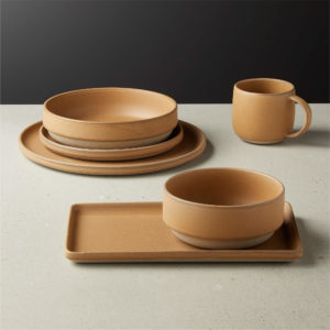 Caramel colored plates, bowls and mugs