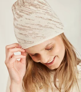 woman wears beige and tac fine knit beanie with organic pattern