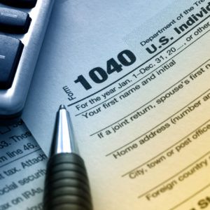 closeup of tax form, pen, and calculator