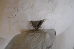 Closeup: thermal insulation of a pipe; insulation is asbestos; breached