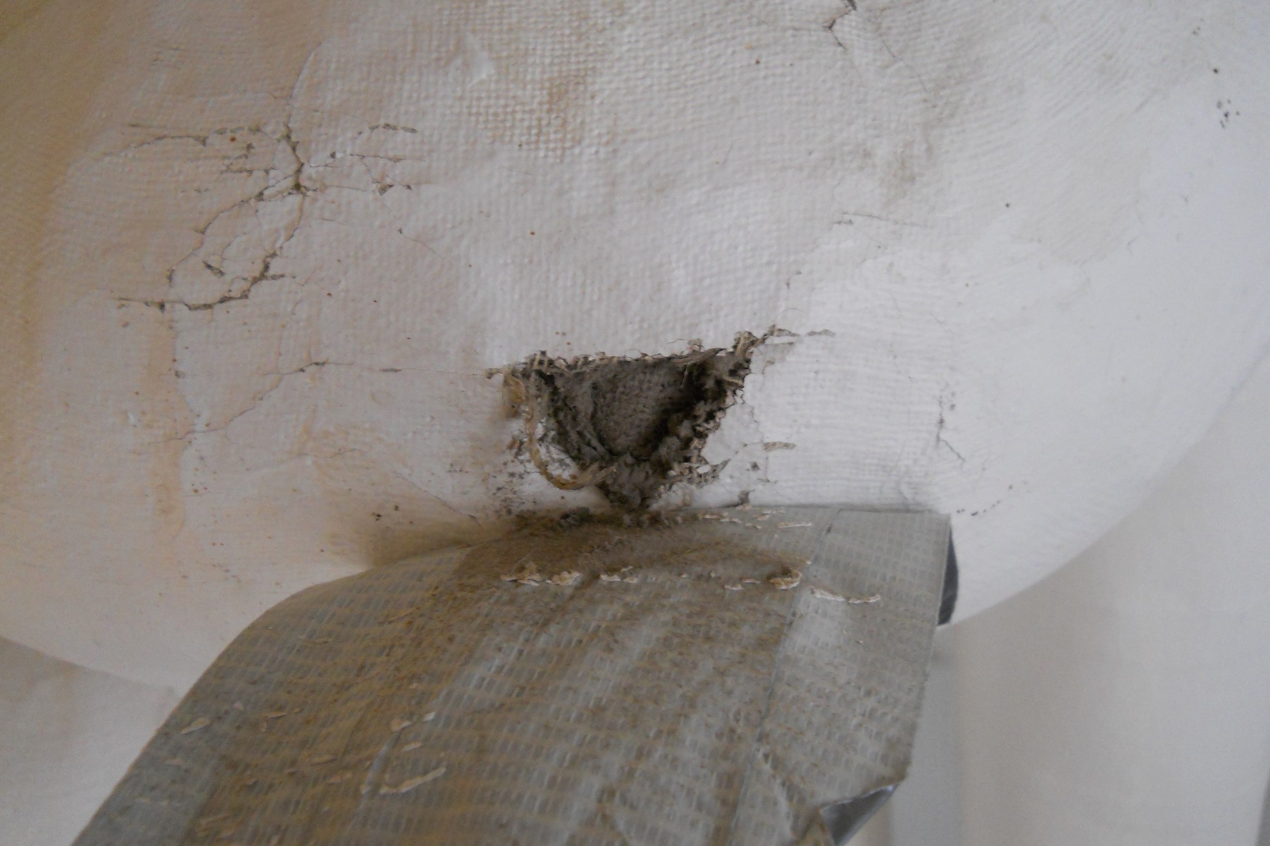 Closeup: thermal insulation of a pipe; insulation is asbestos; breached 
