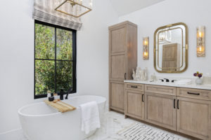 Bathroom with wooden cabinets and window view of plants