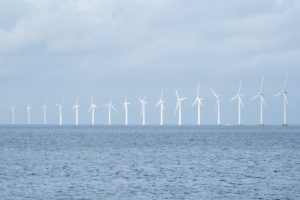 From a distance: wind turbines in a row above the surface of water