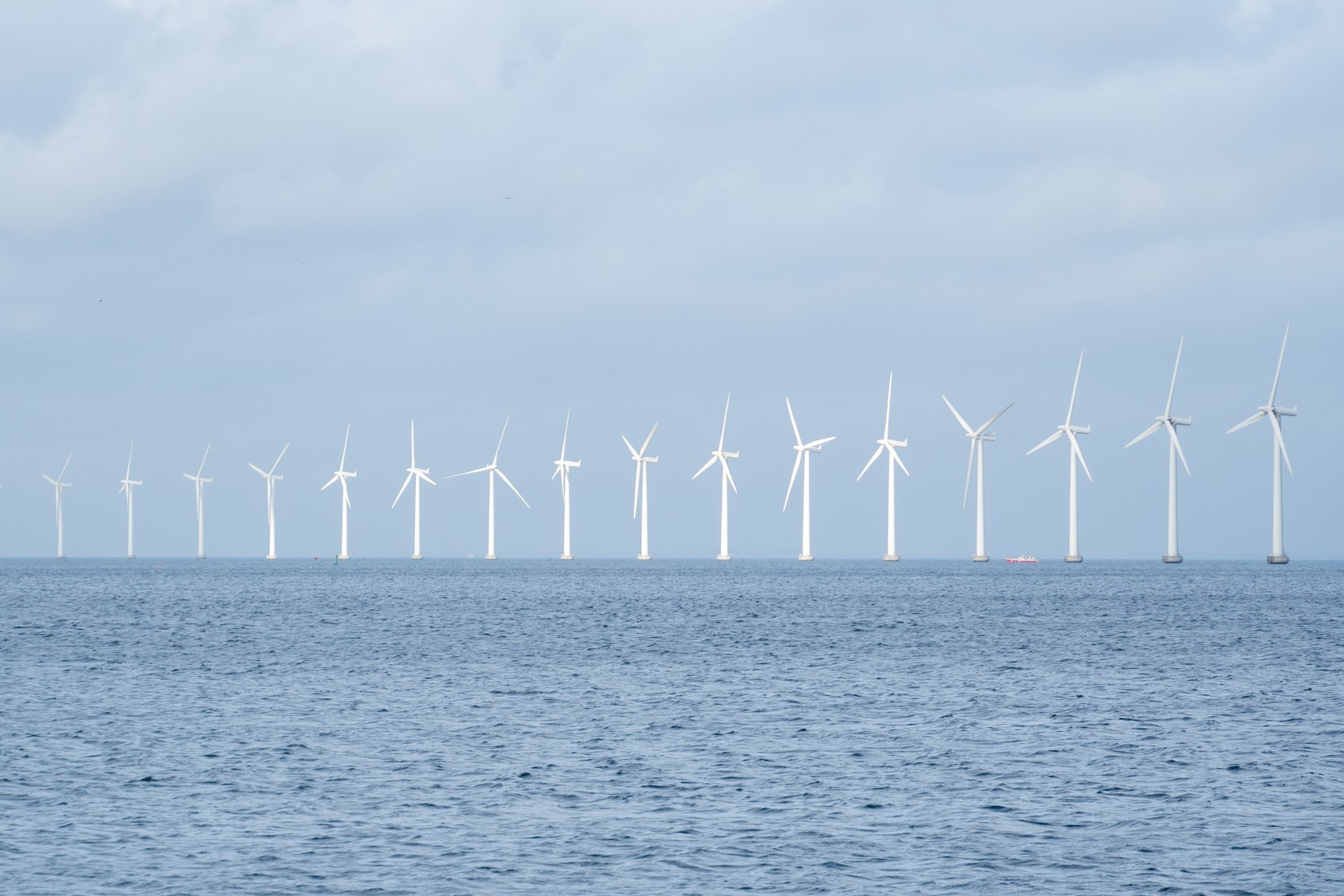 From a distance: wind turbines in a row above the surface of water