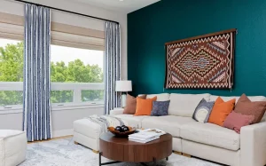 livingroom with white couch and blue striped drapes, wood coffee table cloudy run, and textile art add biophilia