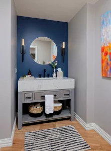 bathroom vairty with dark-blue accents wall and large stone vanity and baskets