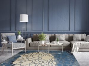 striking livingroom show blue walls with inset panels and sreiking organic area rug in blue, white and gray pattern