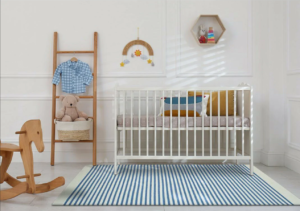 Baby's room with white crib features natural-wood decorations and blue and white striped area rug