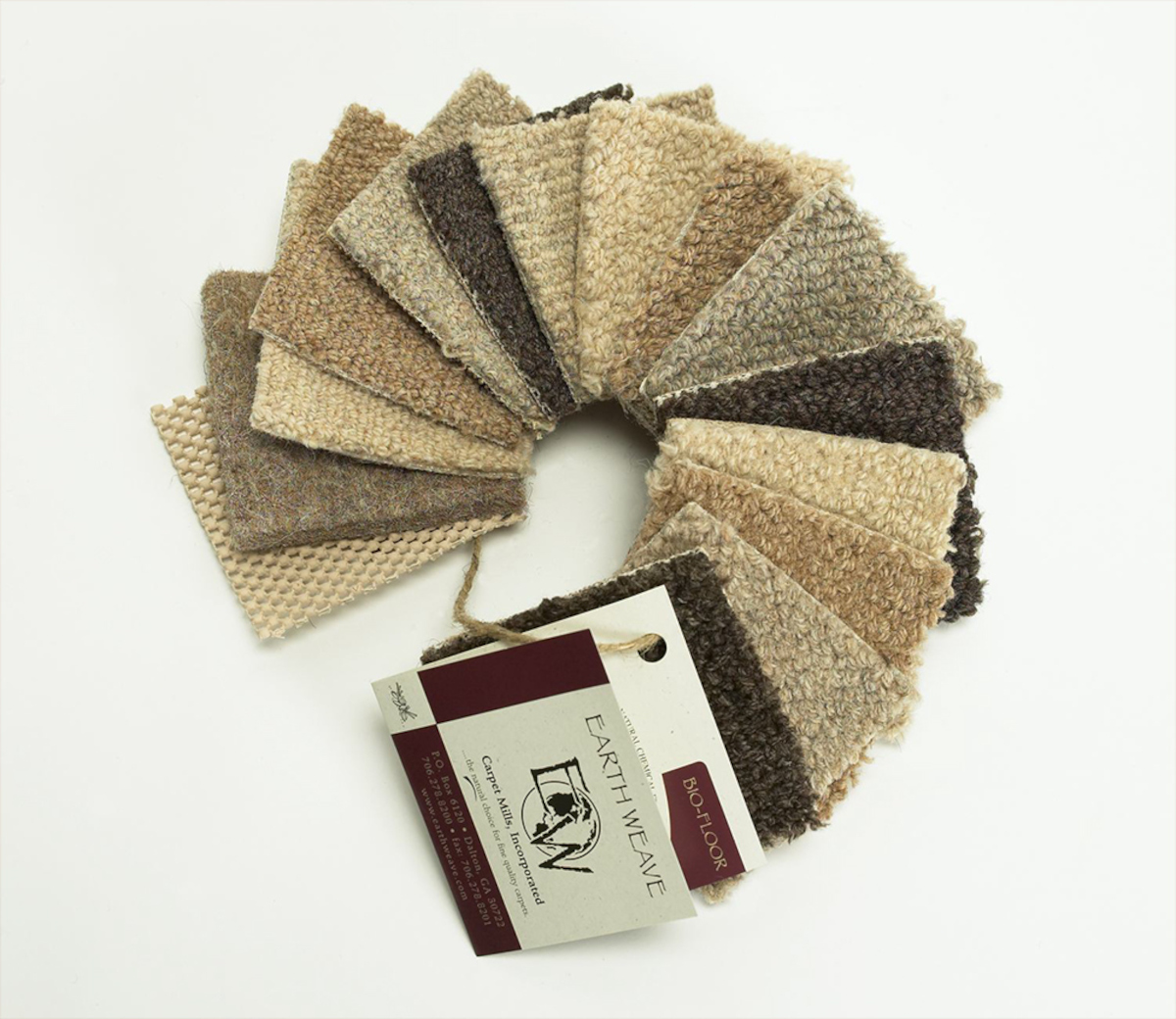 A fan of beige carpet sample with tag showing Earth Weave logo