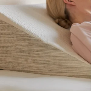 Closeup of nontoxic wedge pillow with woman's head and shoulders resting on it - photo