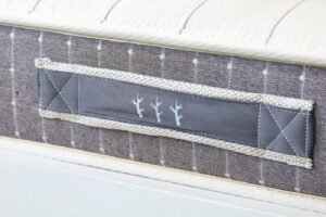 Closeup of nontoxic kids mattress showing Brentwood Home logo in detailed stitching