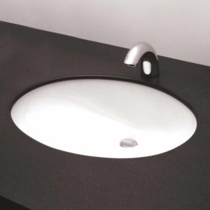 Rimless oval sink recessed into black counter; white wall in background