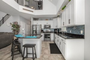 Well-appointed kitchen in double-height modular home: attractive interior design, shows hallways to upper and lower rooms