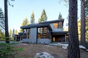 Modern home with contrasting trim in shady woodland setting - photo