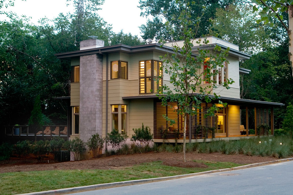 Modern-looking two-story home in wooded setting (exterior); slatted window treatment, chimney, back deck - photo
