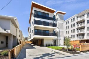 exterior view of three-story modular multifamily bldg, modern style with balconies and canted roof - photo