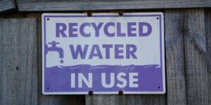 Recycled Water In Use Purple Color Signage in front of a house gate - photo