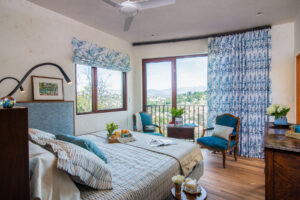 Bedroom with wihite succo walls, wood floows and blue and white textiles; sunny windows - photo