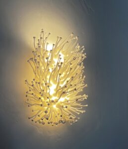 glowing wall sconce shows fine protruding stems - photo